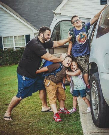dad-pushing-kids-into-car